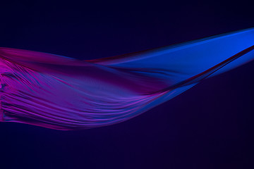 Image showing Smooth elegant transparent blue cloth separated on blue background.