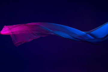 Image showing Smooth elegant transparent blue cloth separated on blue background.