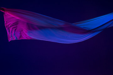 Image showing Smooth elegant transparent blue cloth separated on blue background.