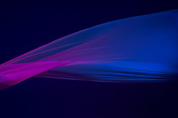 Image showing Smooth elegant transparent blue cloth separated on blue background.