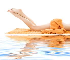 Image showing long legs of relaxed lady with orange towel