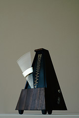 Image showing Vintage metronome, on a black background.