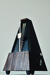 Image showing Vintage metronome, on a black background.