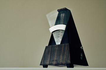 Image showing Vintage metronome, on a black background.