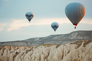 Image showing Three hot air balloons flying over the rocks of Cappadocia