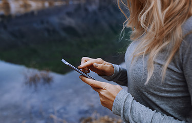 Image showing Woman using smartphone at the lake