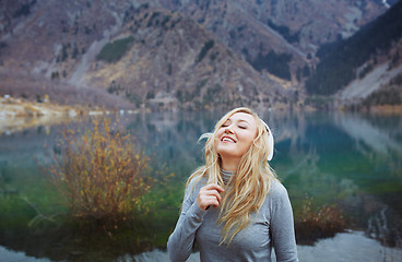 Image showing Woman wearing wireless headphones at the lake