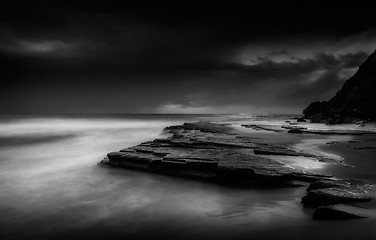 Image showing Dark storm clouds moving out to sea at dawn