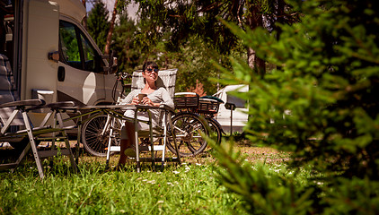 Image showing Woman with a mug of coffee near the camper. Caravan car Vacation