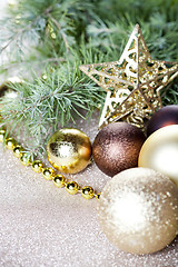 Image showing Christmas fir tree branch, golden star, brown balls.