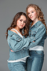 Image showing Full length of young slim female girl in denim jeans on gray background