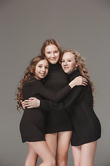 Image showing The fashion girls standing together and looking at camera over gray studio background