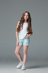 Image showing Full length of young slim female girl in denim shorts on gray background