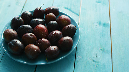 Image showing Plums on blue plate on table