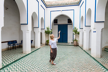 Image showing Woman admiring traditional moroccan architecture in one of the palaces in medina of Marrakesh, Morocco.