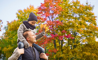 Image showing happy father carrying son with autumn maple leaves