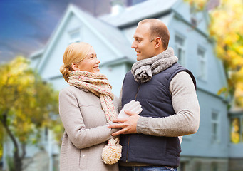 Image showing happy couple over living house in autumn