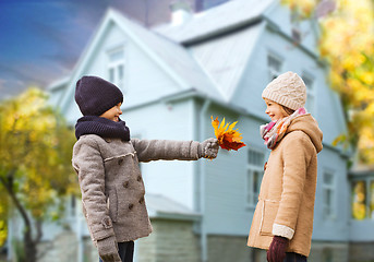 Image showing kids with autumn maple leaves over house outdoors