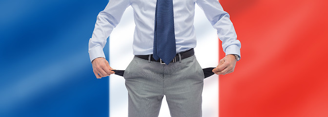 Image showing businessman with empty pockets over flag of france