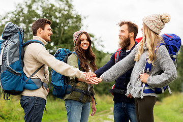 Image showing friends with backpacks hiking and stacking hands