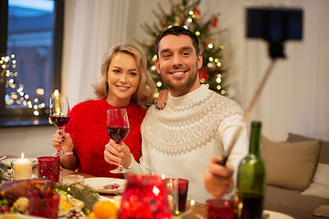 Image showing couple taking picture by selfie stick at christmas