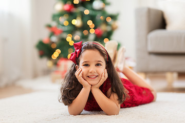 Image showing happy girl lying on floor at home on christmas