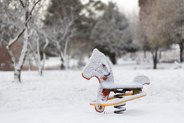 Image showing Playground equipment rocking horse covered in snow