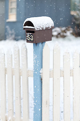 Image showing Mailbox and picket fence with falling snow in winter