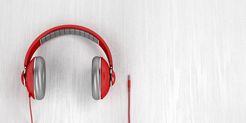 Image showing Big red headphones on wood background