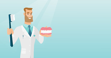 Image showing Dentist with a dental jaw model and a toothbrush.