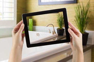 Image showing Female Hands Holding Computer Tablet In Bathroom with Photo on S