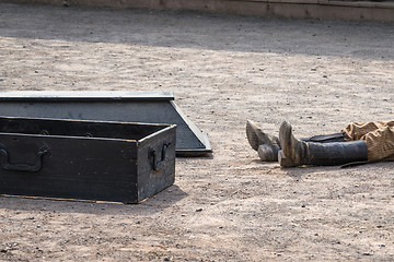 Image showing Coffin next to a dead man with his boots