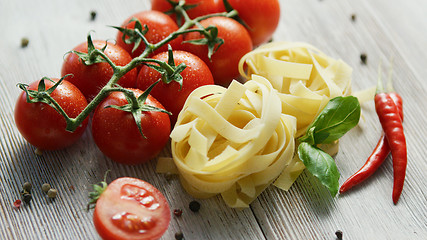 Image showing Uncooked pasta bunches with tomatoes