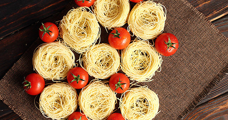 Image showing Uncooked pasta bunches and tomatoes