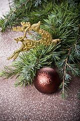 Image showing Evergreen fir tree branch, golden deer, brown ball.