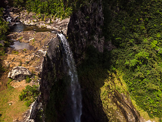 Image showing Aerial top view perspective of amazing 500 feet tall waterfall in the tropical island jungle of Mauritius.