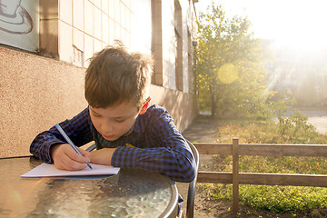 Image showing Boy doing homework outdoors