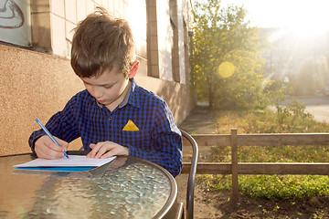 Image showing Boy doing homework outdoors