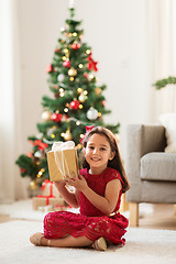 Image showing happy girl with christmas gift at home