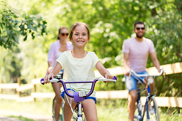 Image showing happy family riding bicycles in summer park