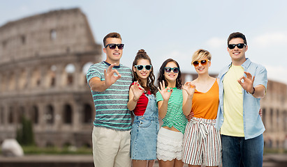 Image showing friends in sunglasses showing ok over coliseum