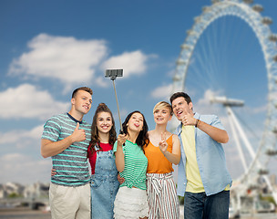 Image showing friends taking selfie over ferry wheel in london