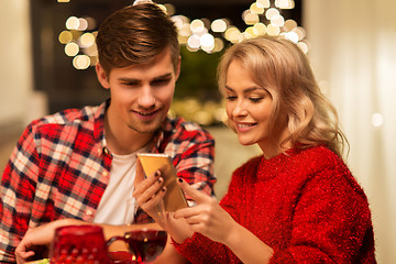 Image showing couple with smartphone at home christmas dinner