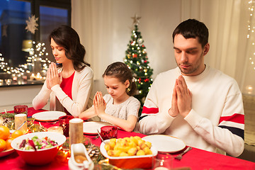 Image showing family praying before meal at christmas dinner