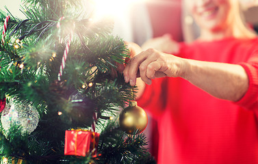 Image showing close up of senior woman decorating christmas tree