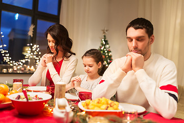 Image showing family praying before meal at christmas dinner