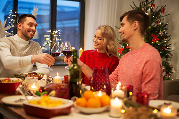 Image showing happy friends drinking red wine at christmas party