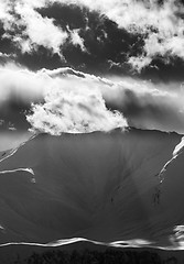 Image showing Black and white view on evening snow mountains with sunlit cloud