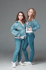 Image showing Full length of young slim female girl in denim jeans on gray background