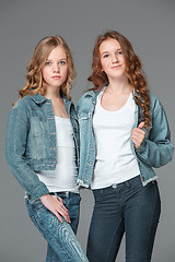 Image showing Full length of young slim female girl in denim jeans on gray background